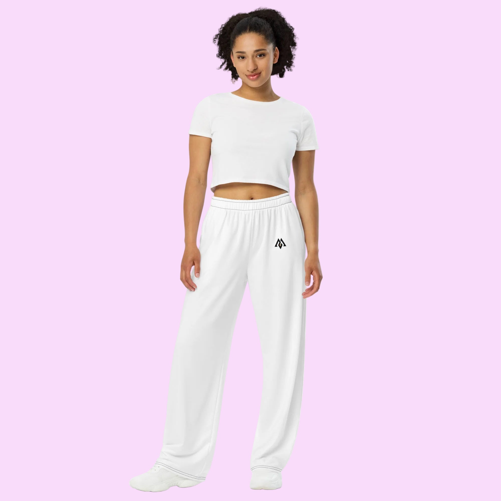Woman wearing a white crop top and white sweatpants with a logo on a white background