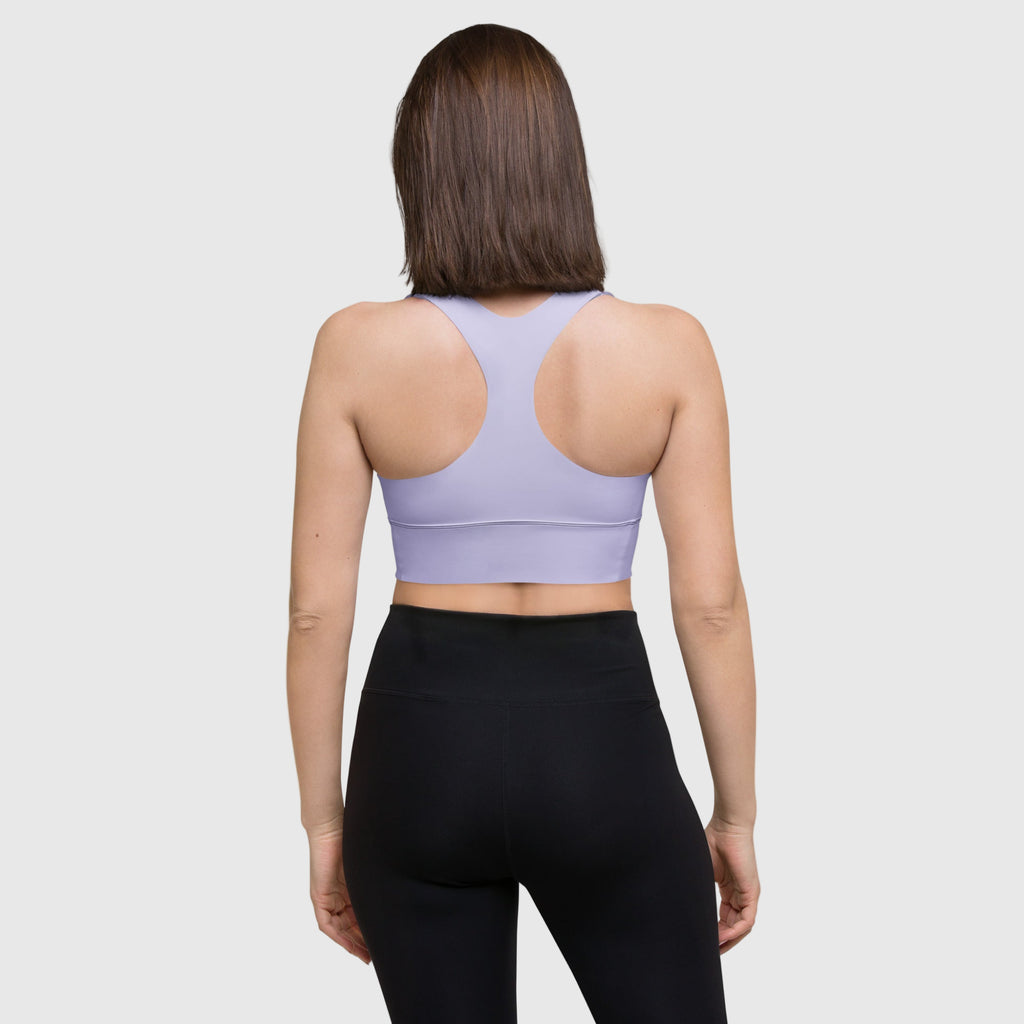 Person wearing a light purple sports bra and black leggings on a white background