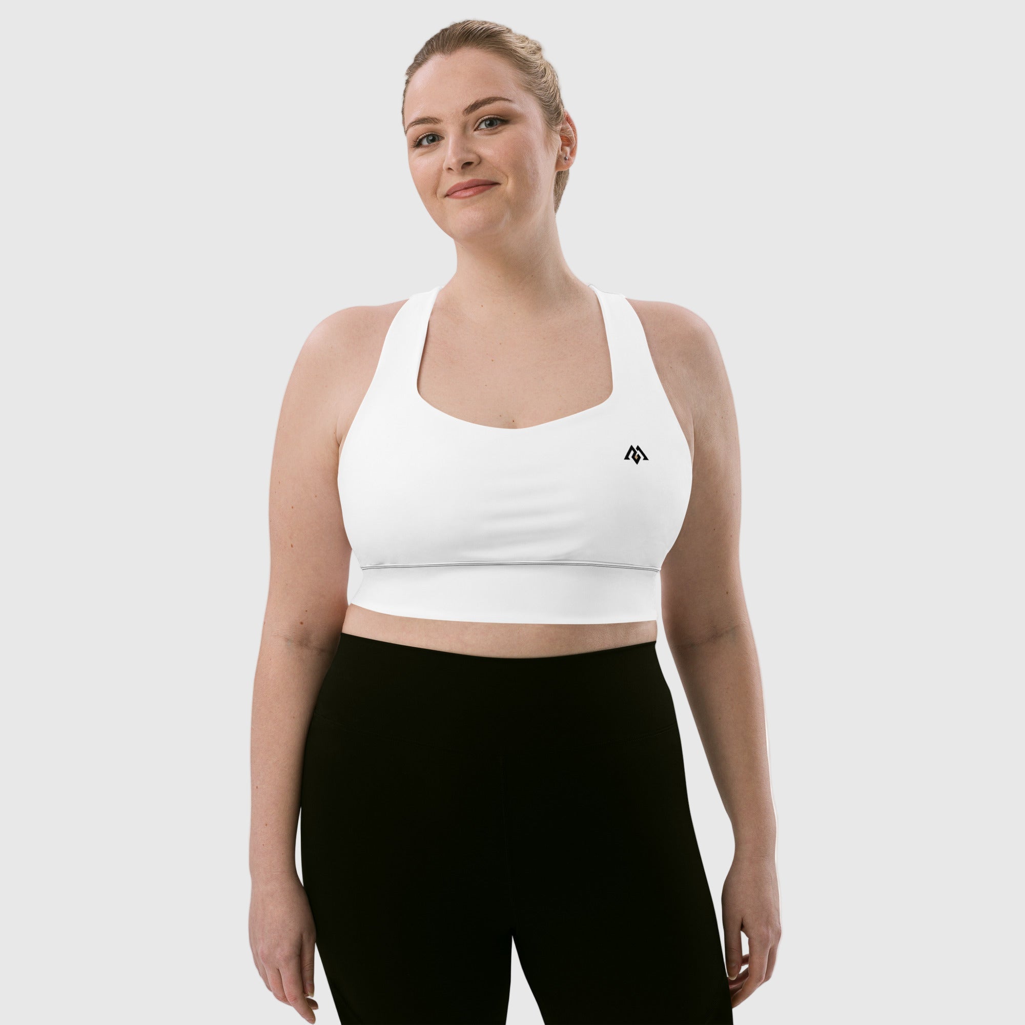 Woman wearing a white sports bra and black leggings on a white background