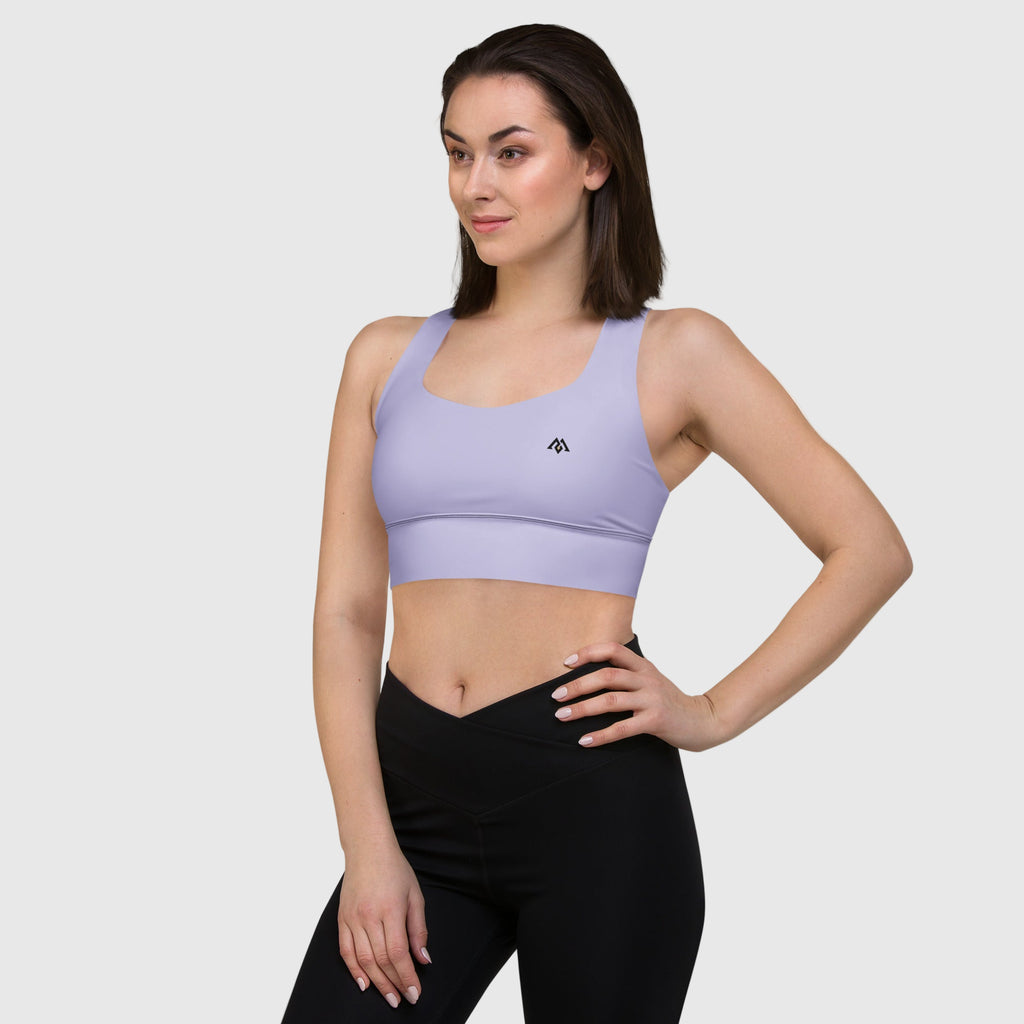 Woman wearing a purple sports bra and black leggings on a white background