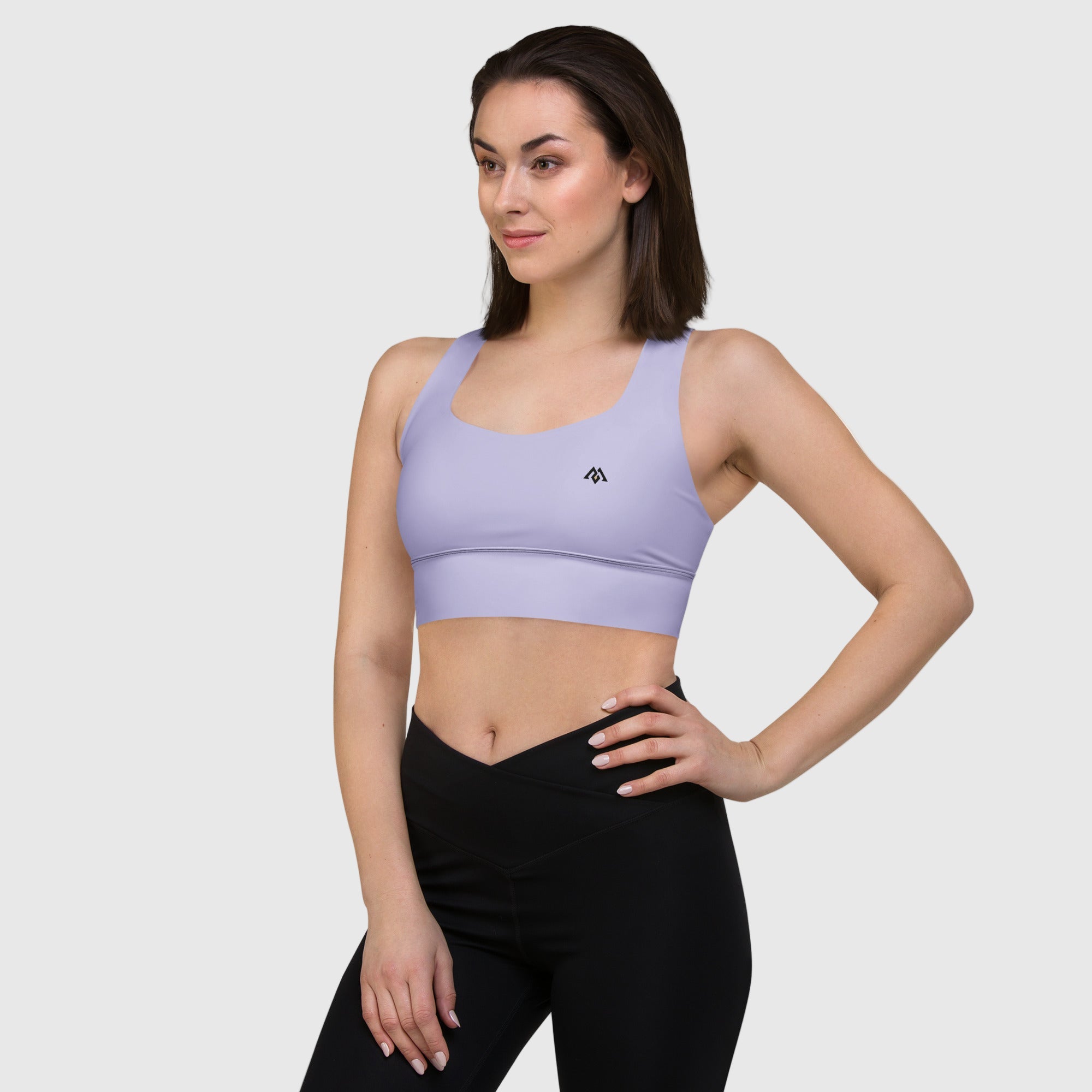 Woman wearing a purple sports bra and black leggings on a white background