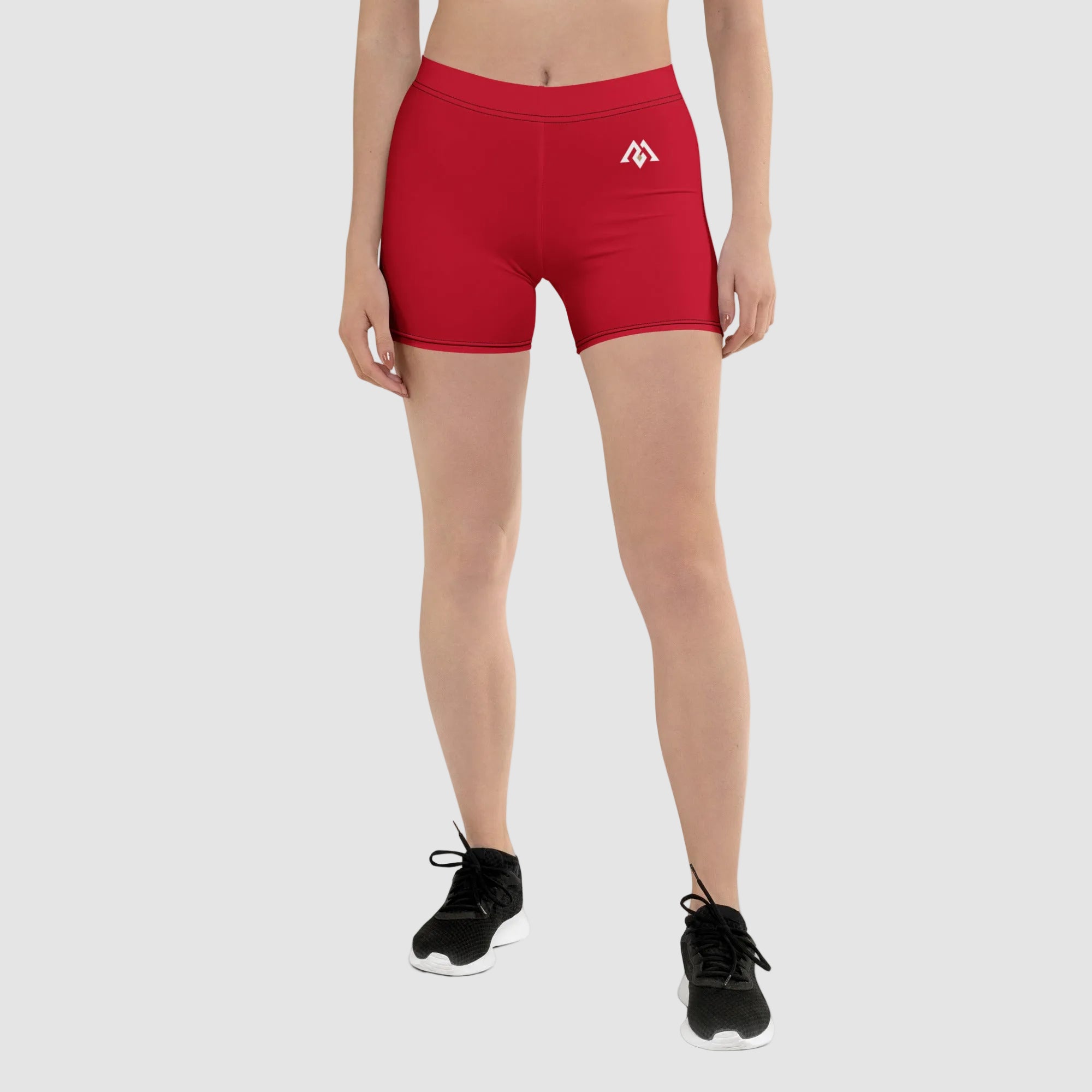 Red athletic shorts with a logo worn by a person on a white background