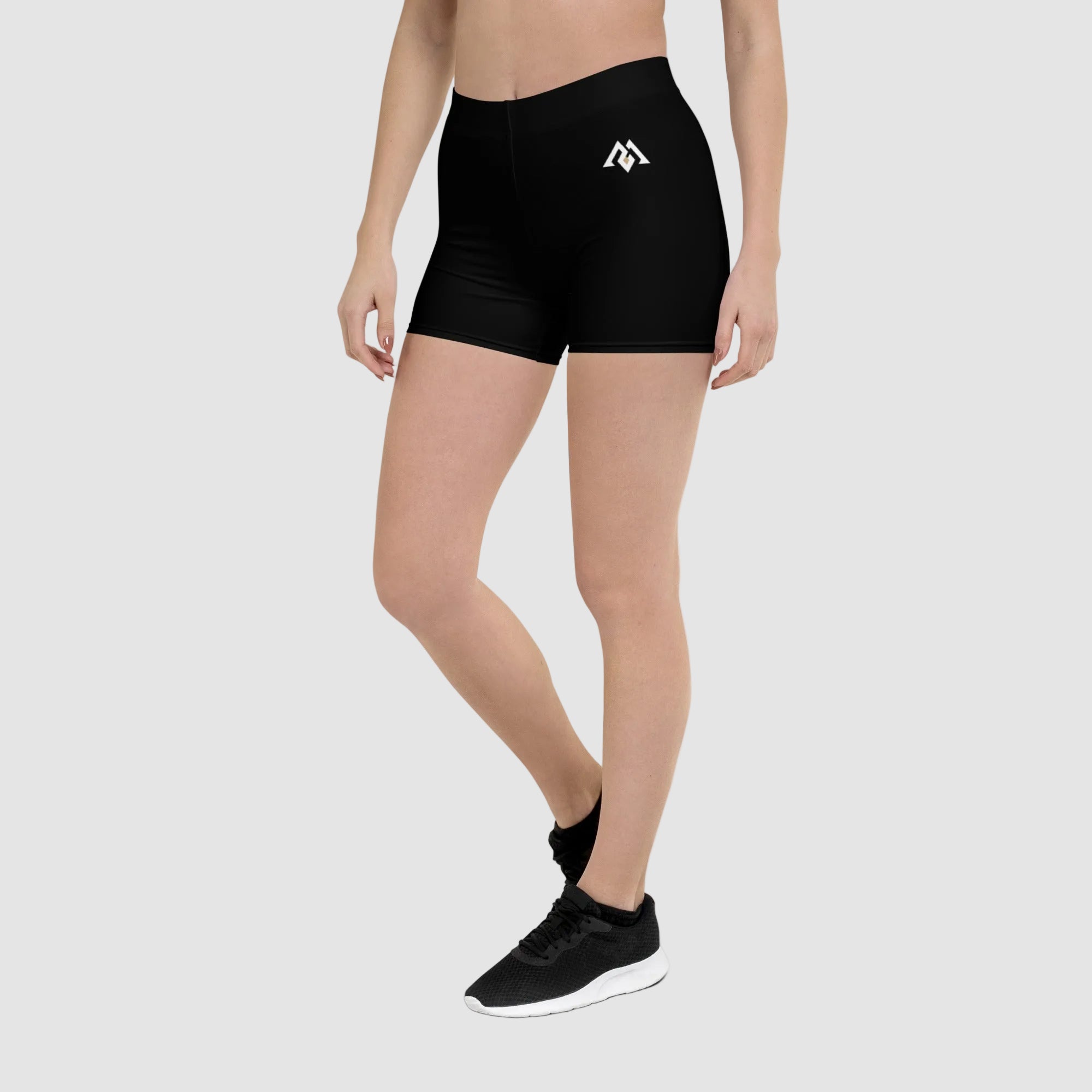 Person wearing black athletic shorts with a logo on a white background