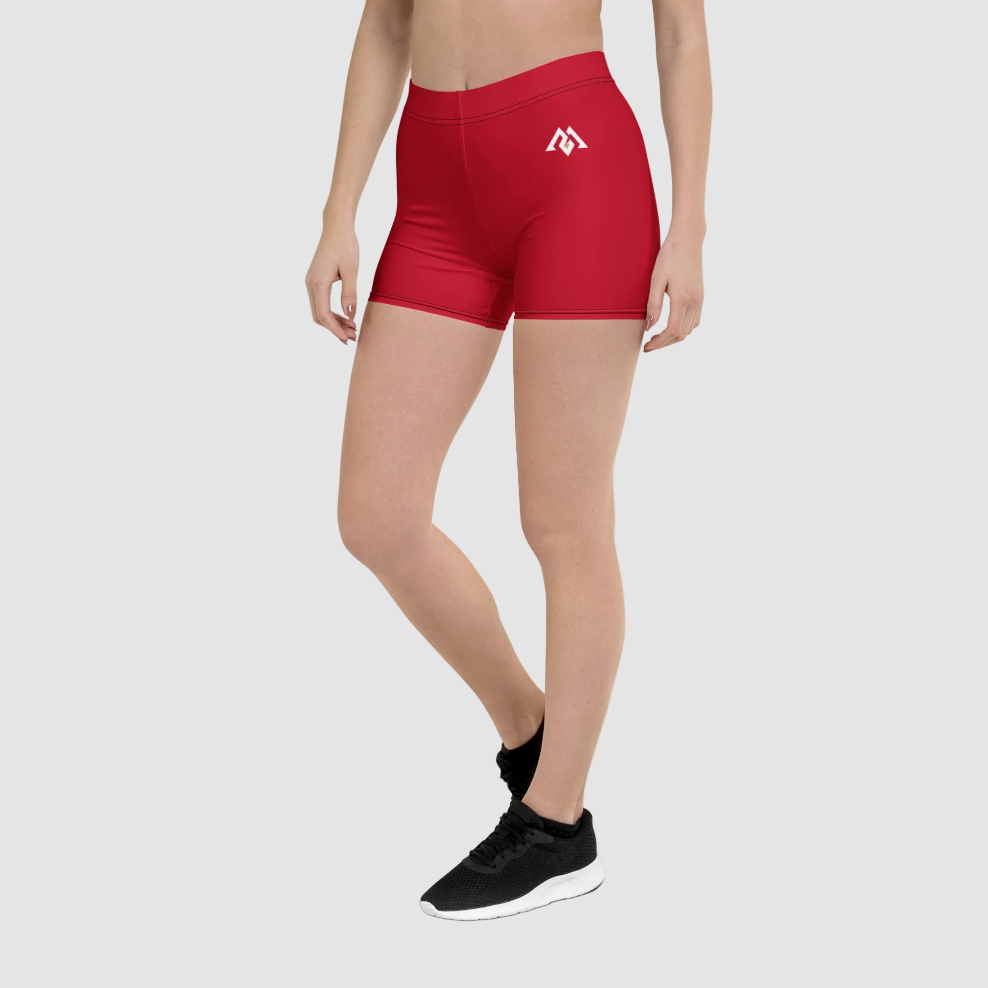 Red athletic shorts with a logo worn by a person on a white background