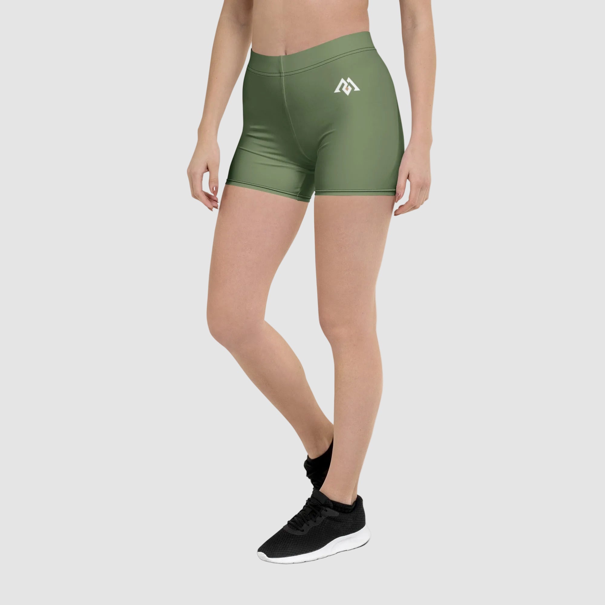 Person wearing green athletic shorts with a logo on a white background