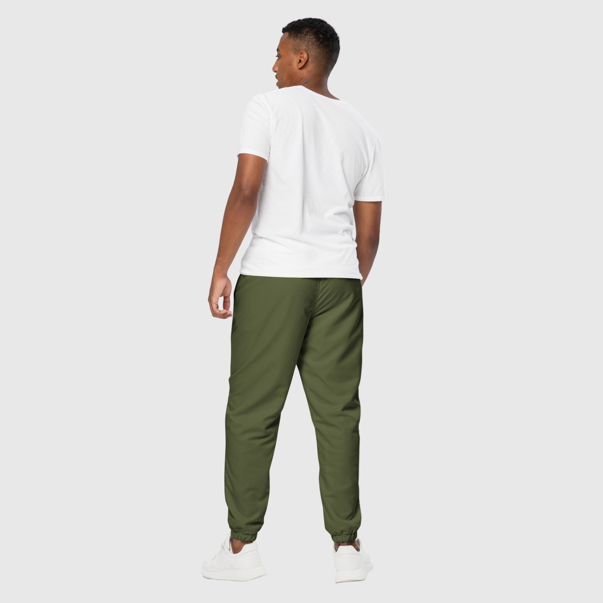 Model wearing ActiveAegis Unisex Track Pants in Saratoga Green – tapered, breathable, sustainable joggers made from recycled fabric for gym and casual wear.