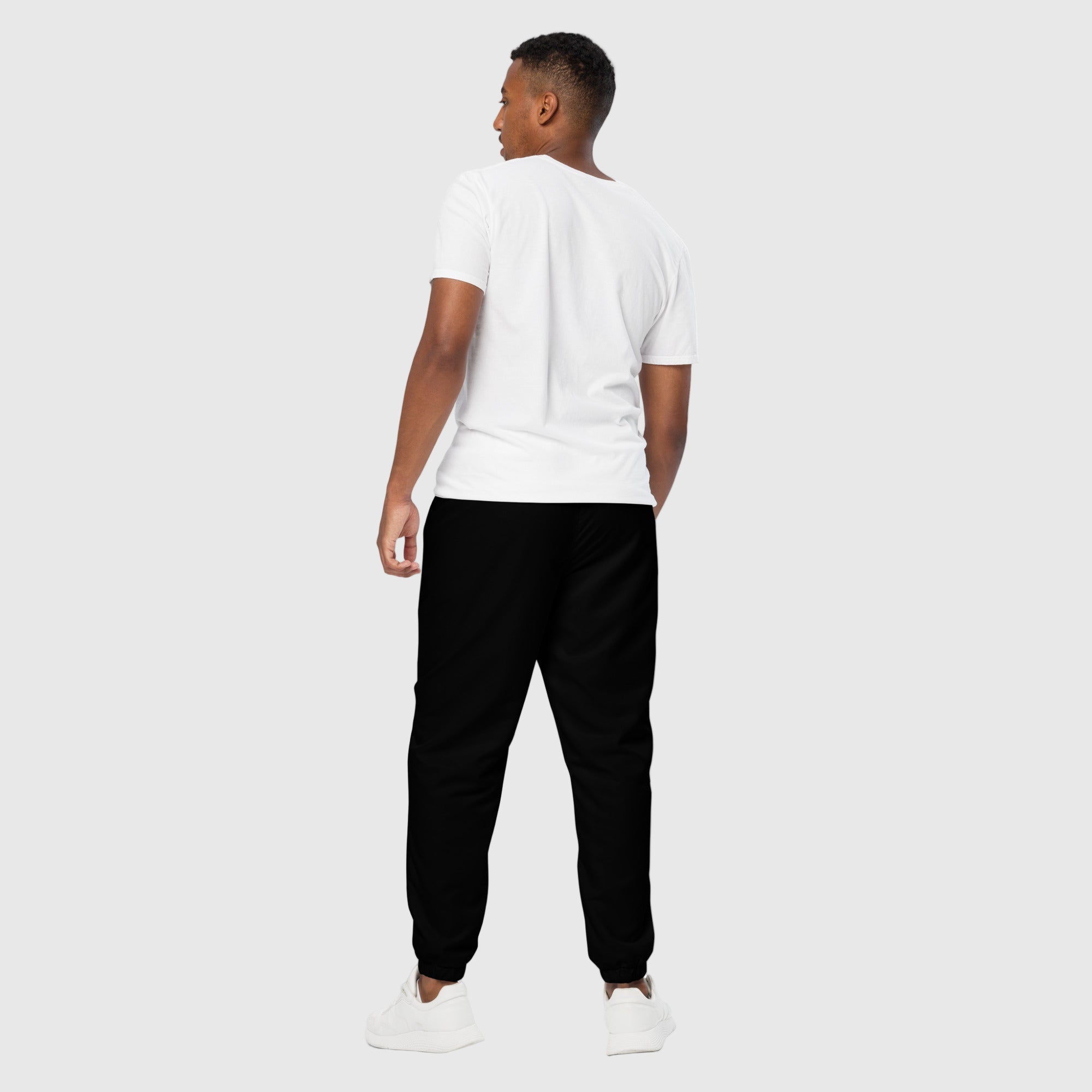 Model wearing ActiveAegis Unisex Track Pants in black – sustainable, breathable, tapered performance joggers for gym, street, and everyday wear.