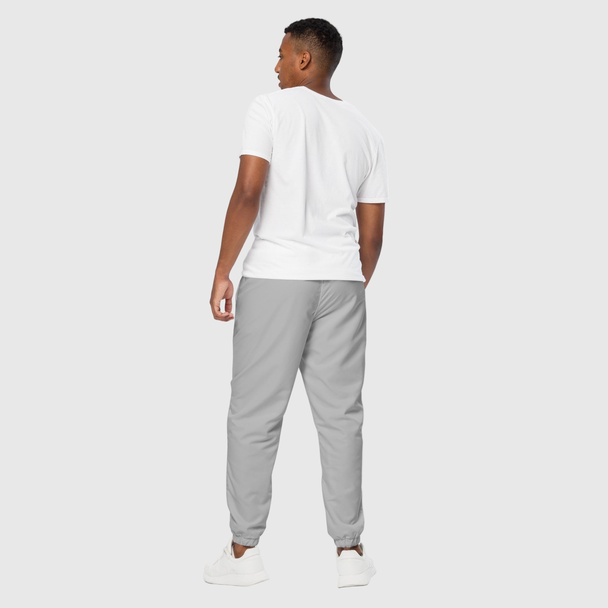 Model wearing ActiveAegis Unisex Track Pants in grey – tapered, breathable, and stretch-fit activewear for workouts and casual comfort
