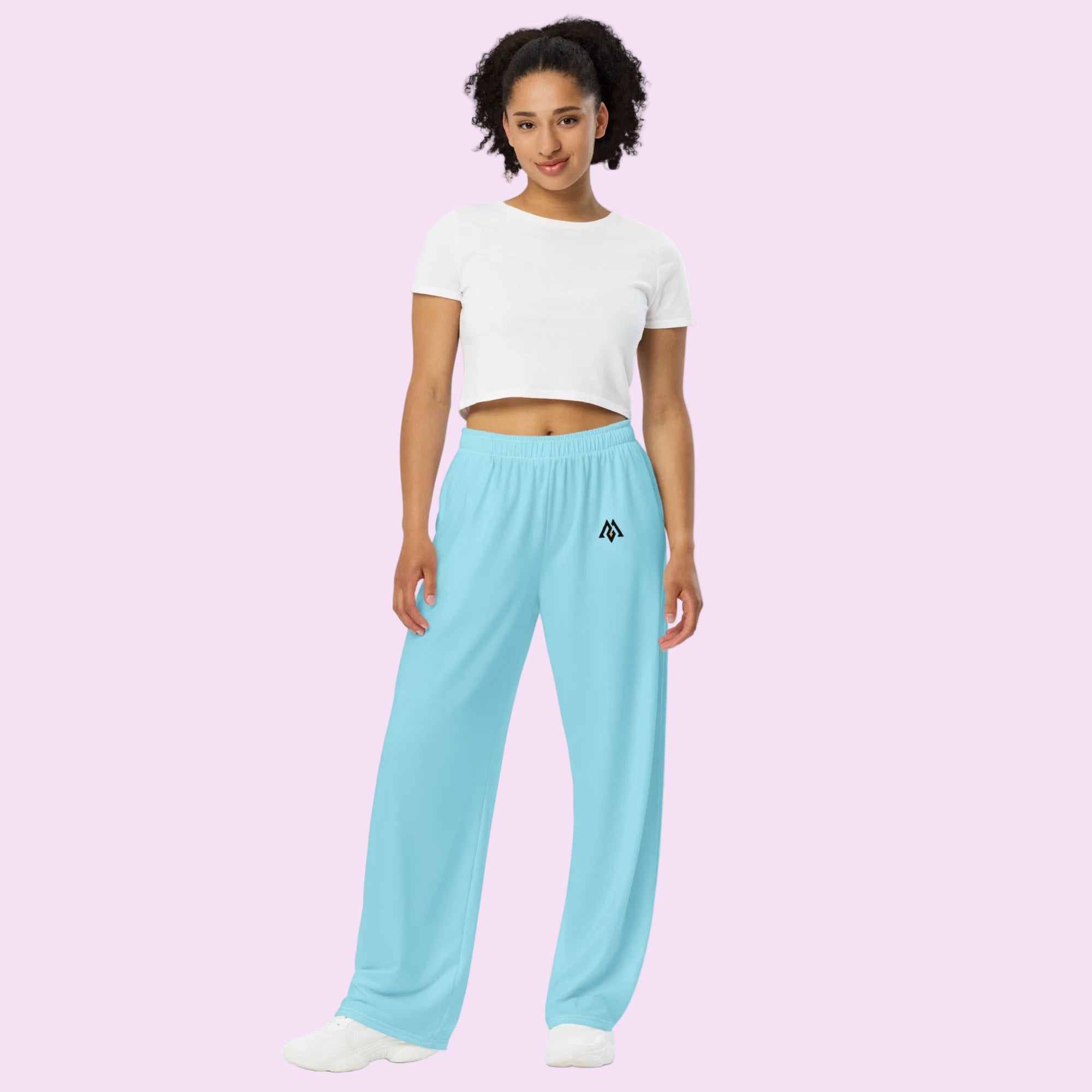 Woman wearing light blue sweatpants with a logo on a white background