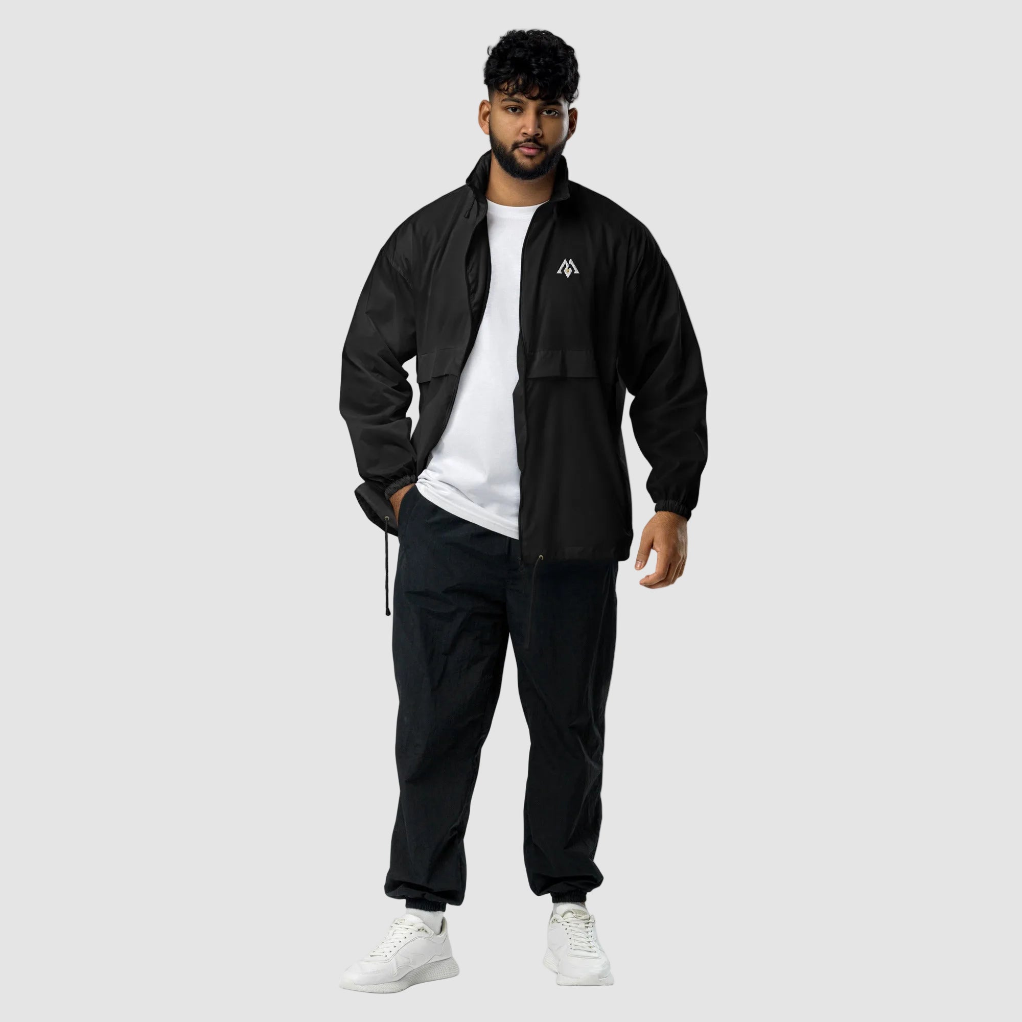 Man wearing a black tracksuit with a logo on a white background